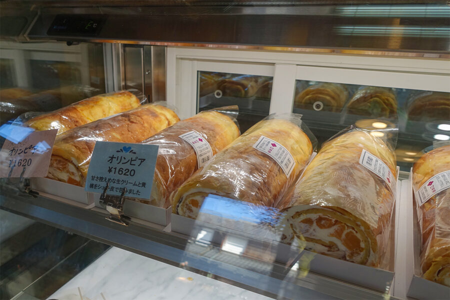 三中井の店内にあるショーケース。名物ロールケーキのオリンピアは1本1,620円で販売されています